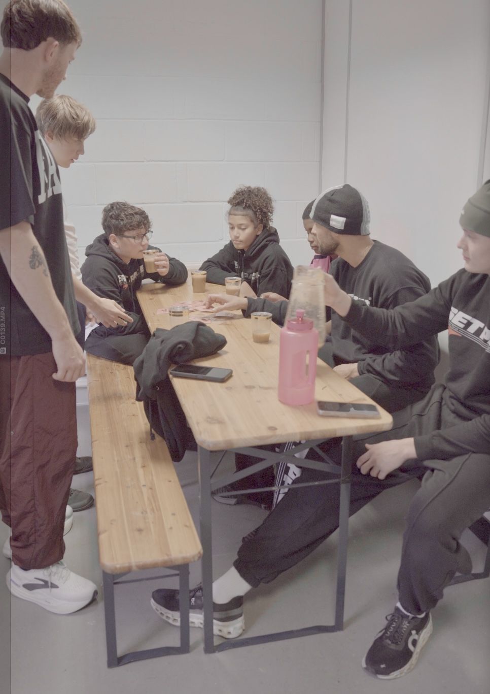 Young people gathered around the table after a session — drinking juice, talking