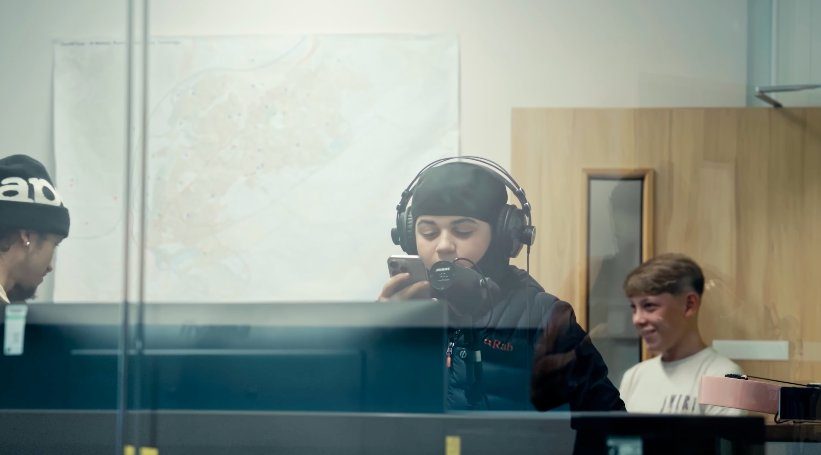 Young person recording in the booth with headphones